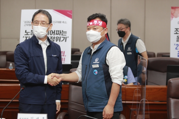 서울교통공사 김상범(왼쪽) 사장과 서울교통공사 노동조합 김대훈 위원장이 지난 13일 열린 임금 및 단체협약 교섭에서 합의안을 체결하고 악수를 하고 있다.