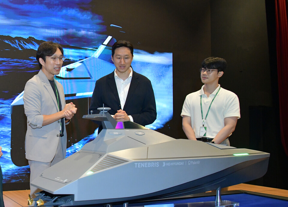 정기선(가운데) HD현대 부회장이 미래기술원 연구원들로부터 팔란티어와 공동개발 중인 무인수상정(USV) '테네브리스'에 대한 설명을 듣고 있다.<HD현대>
