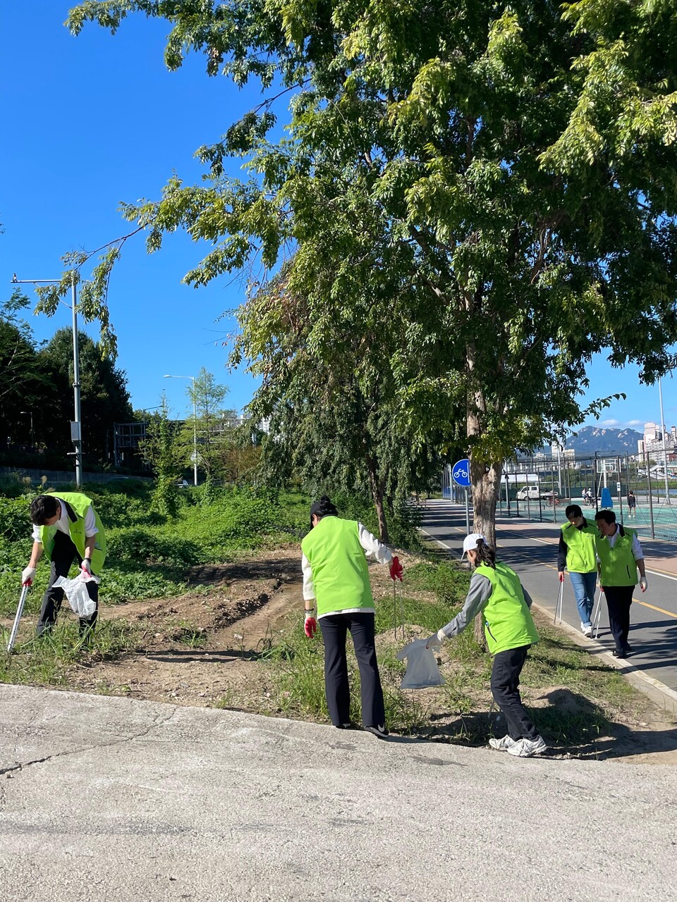 KG스틸 임직원이 지난 23일 서울시 동대문구 중랑천 일대에서 쓰레기를 수거하고 있다.<KG스틸>