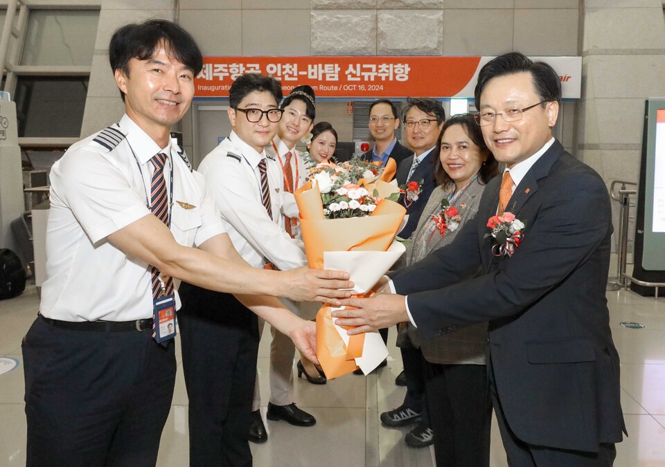 지난 16일 오후 인천국제공항에서 진행된 제주항공 인천~바탐 노선 신규취항식에 참석한 김이배 대표이사(사진 오른쪽 맨 앞) 등 내·외빈들이 승무원들에게 꽃다발을 전달하고 있다.<제주항공>