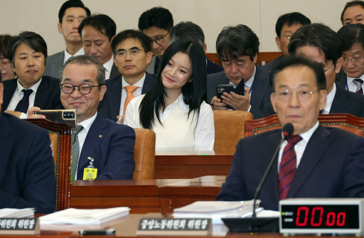 정인섭 한화오션 대외협력실장(거제사업장) 사장이 지난 15일 서울 여의도 국회 환경노동위원회에서 열린 경제사회노동위원회 등에 대한 국정감사에서 걸그룹 뉴진스의 하니와 셀카를 찍고 있다.<뉴시스>