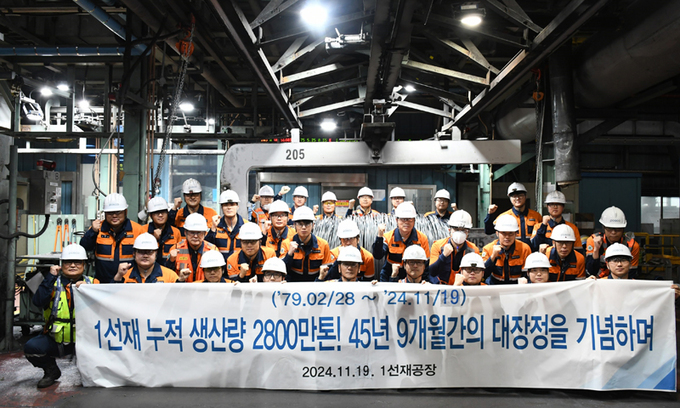 포항제철소 1선재공장 직원들이 공장을 배경으로 기념촬영을 하고 있다.<포스코>