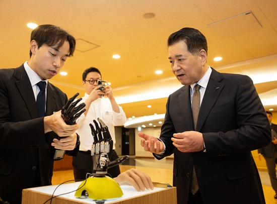 장인화(오른쪽) 포스코1%나눔재단 이사장이 상이 국가유공자 및 현직 소방관·군인에게 전달한 로봇 의수를 살펴보고 있다.<포스코>