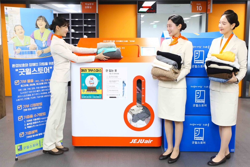 제주항공 임직원들이 지난 23일 서울시 강서구 제주항공 객실승무원라운지에서 안 입는 옷 수거함에 옷을 기부하고 있다.<제주항공>