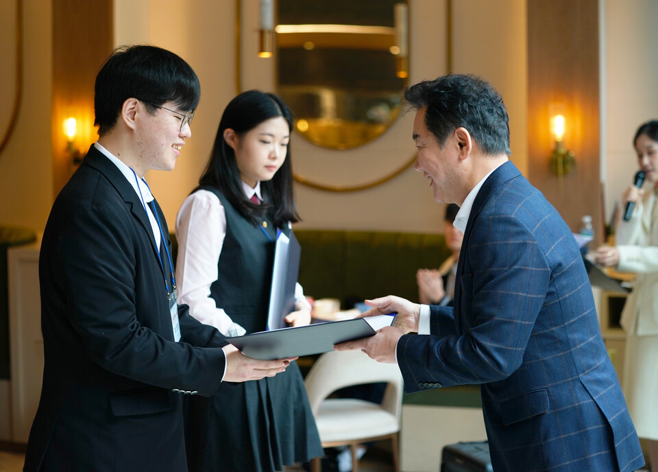 박상원(오른쪽) 천만장학회 이사장 지난해 2월 장학증서 수여식에서 장학생에게 장학증서를 수여하고 있다.<삼천리>