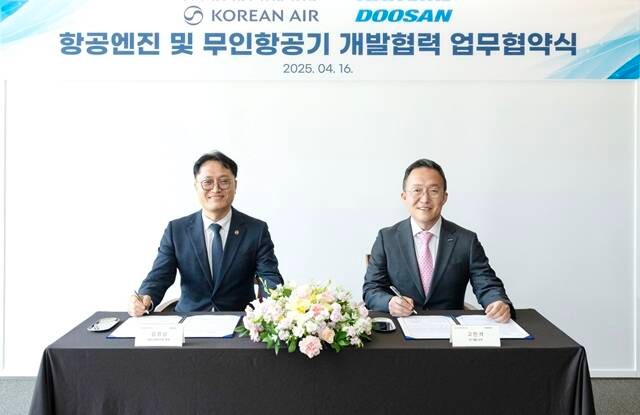 김경남 대한항공 항공기술연구원장(왼쪽)과 고민석 두산에너빌리티 GT개발 담당이 기념 촬영하고 있다.<대한항공>