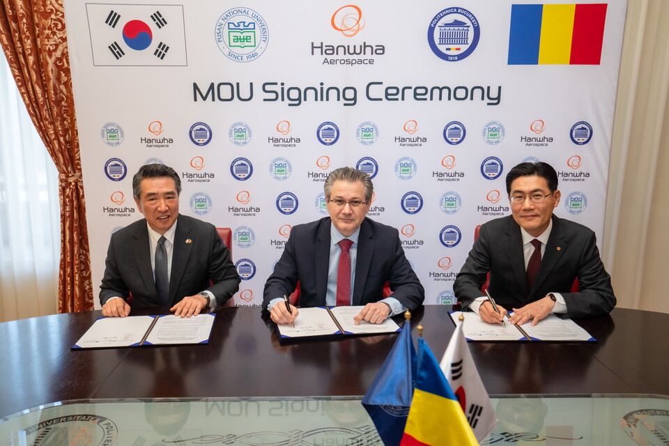 (오른쪽부터) 배진규 한화에어로스페이스 루마니아 법인장과 미흐네아 코스토유 부쿠레슈티 공과대 총장, 임갑수 주 루마니아 대사가 지난 16일(현지시간) 부쿠레슈티 공대에서 열린 MOU 체결식에서 서명을 하고 있다.<한화에어로스페이스>
