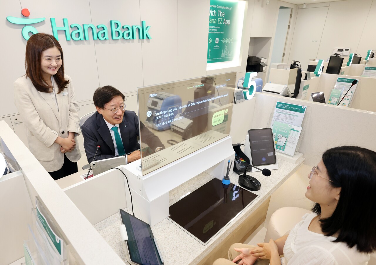 이승열 당시 하나은행장(현 하나금융지주 부회장)이 지난해 9월 개점한 외국인 고객 특화점포 평택외국인센터점에서 AI 통·번역 시스템이 탑재된 투명 패널을 통해 외국인 고객에게 금융 상담을 하고 있다.<하나은행>
