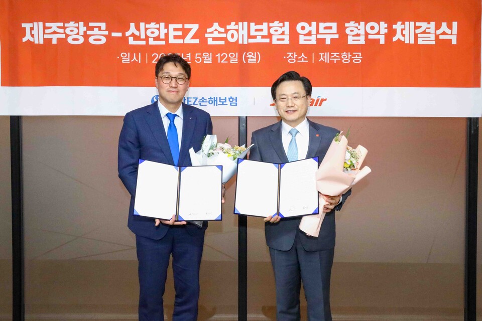 김이배 제주항공 대표이사(오른쪽)와 강병관 신한EZ손해보험 대표이사가 지난 12일 오후 서울 강서구에 위치한 제주항공 서울지사에서 상호협력을 위한 업무협약을 체결한 뒤 기념촬영을 하고 있다.<제주항공>