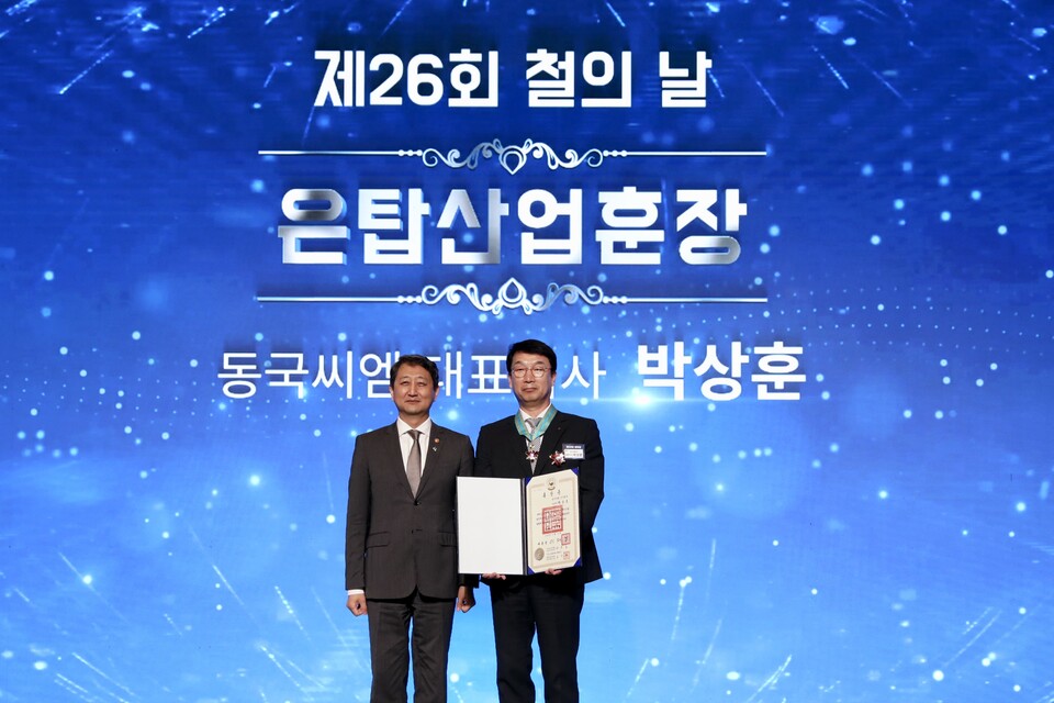 박상훈 동국제강그룹 동국씨엠 사장(오른쪽)이 철의 날을 맞아 은탑산업훈장을 받은 뒤 안덕근 산업부 장관과 기념촬영을 하고 있다.<동국제강그룹>