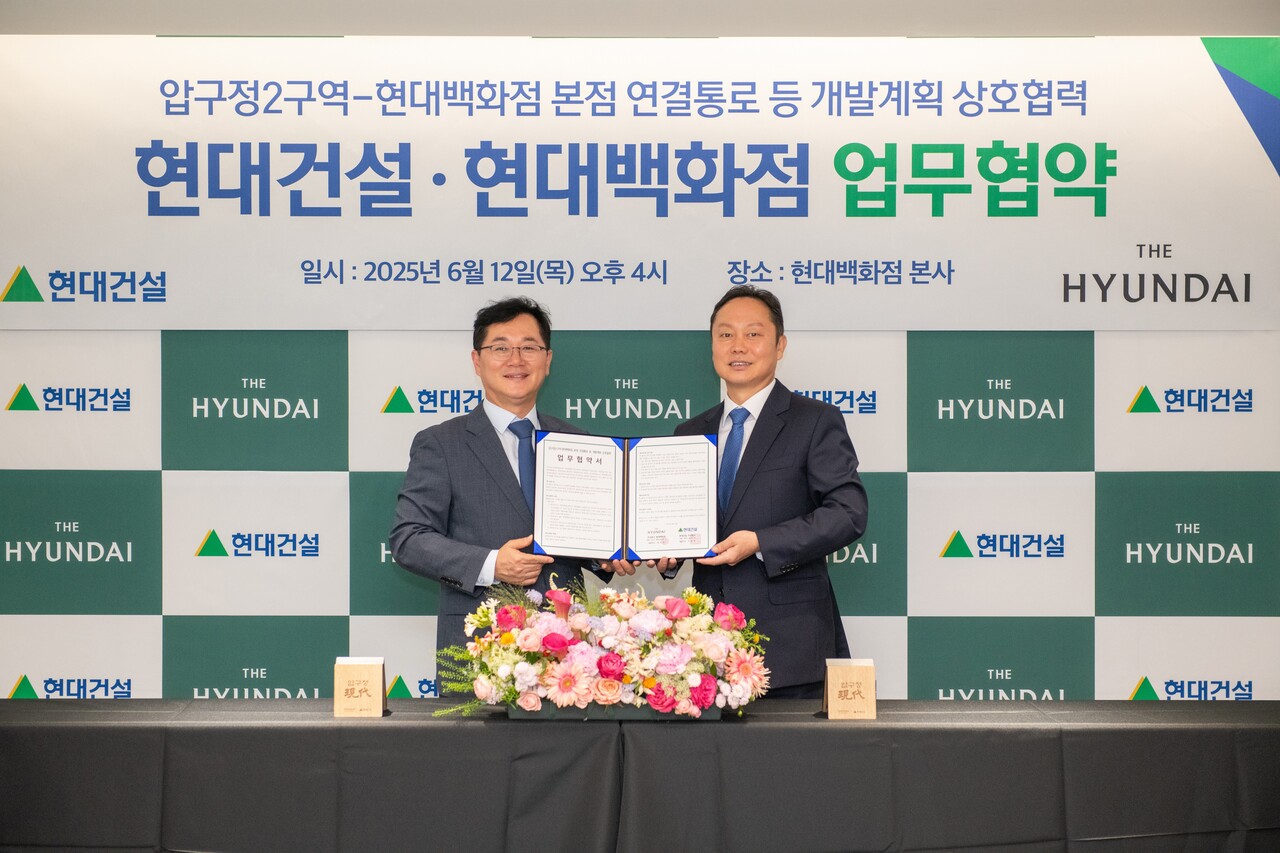 이인기 현대건설 주택사업본부장(왼쪽)과 김창섭 현대백화점 영업본부장이 협약식을 마치고 기념촬영을 하고 있다.<현대건설>