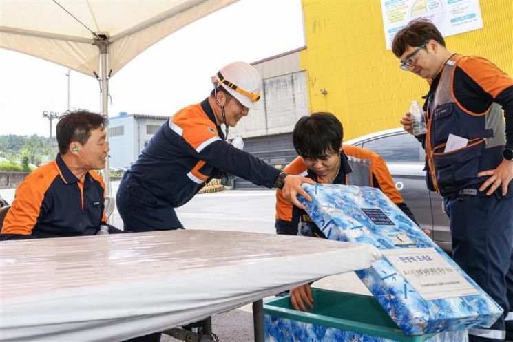 포스코 포항제철소 직원들이 그늘막 아래에서 물을 꺼내고 있다.<포스코>