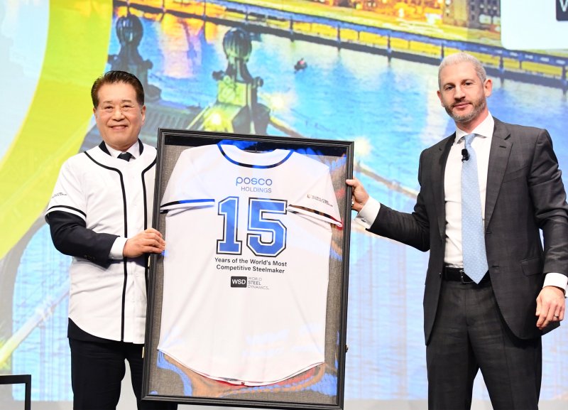 지난 6월 18일(현지시간) 미국 뉴욕에서 열린 WSD 포럼에서 장인화 포스코 회장(왼쪽)이 필립 엥글린 WSD CEO로부터 야구복으로 특별 제작한 WSD 명예의 전당 기념액자를 전달 받은 뒤 기념촬영을 하고 있다.<포스코>