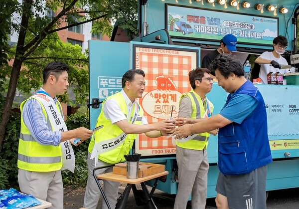 24일 경기도 수원시 소재 CJ대한통운 서브터미널에서 윤재승 CJ대한통운 O-NE 본부장(왼쪽에서 두 번째)이 택배기사에게 커피와 쿨링패치 등 여름나기 용품을 전달하고 있다. CJ대한통운 제공