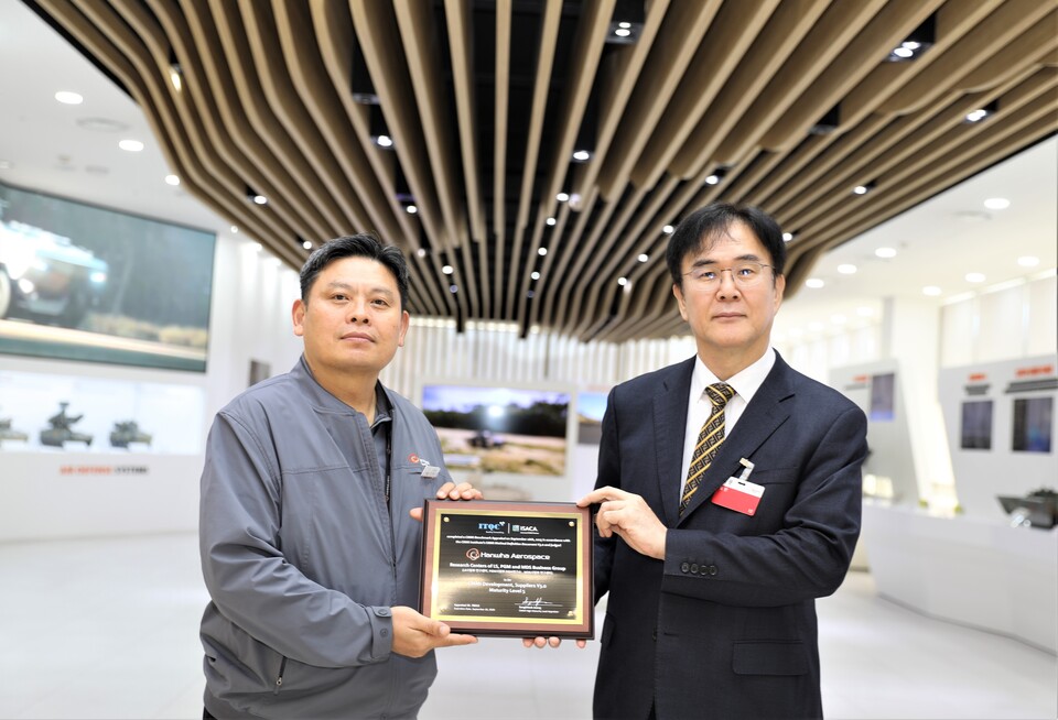 안홍규(왼쪽) 한화에어로스페이스 임원(왼쪽)과 정상욱 CMMI High Maturity 선임심사원(ITQC 대표)가 인증 후 기념촬영을 하고 있다.<한화에어로스페이스>
